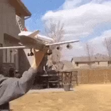 Ein Spielzeug- Flugzeug wird von jemandem in die Luft geworfen, landet sofort auf dem Boden und ist kaputt