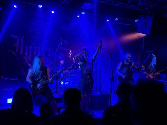 Five piece band Inner Sanctum on stage lit up in blue